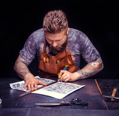 Deri işçisi deri stüdyoda yeni deri ürünler üretiyor.