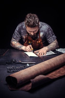 Deri işçisi işyerinde deri ile çalışır.