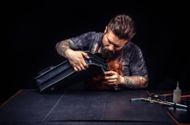 Deri giyen adam deri işçiliği yapıyor.