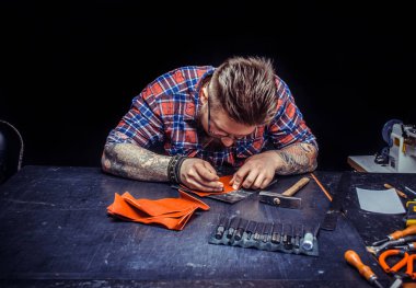 El sanatları ustası yeni yapımı için deri kaplama kesiyor.