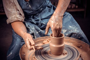 Usta zanaatkar çömlek çarkında seramik demlik yapıyor. Kadın için serbest çalışma, iş, hobi kavramı. Yakın plan..
