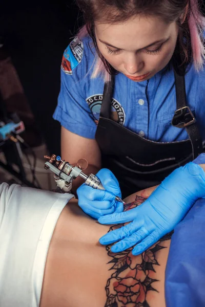 Il maestro tatuatore dimostra il processo di tatuarsi nel salone del tatuaggio — Foto Stock