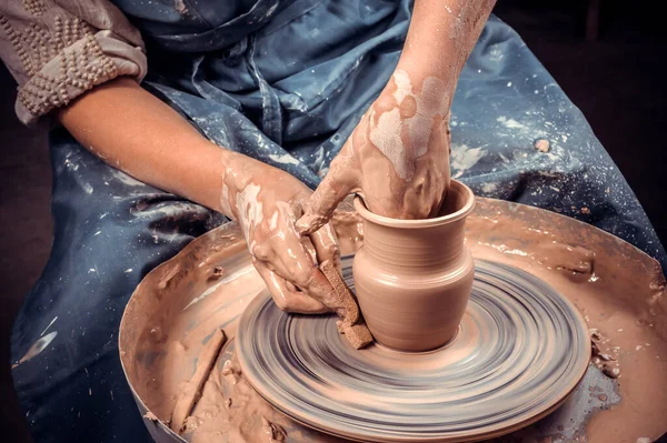 Potters händer och krukmakare hjul. Närbild. — Stockfoto