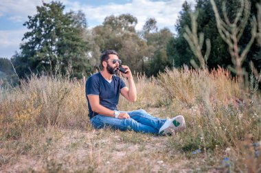 Modern adam ormanda elektronik bir duman cihazının keyfini çıkarıyor. Tütün içilmeyen sigara.