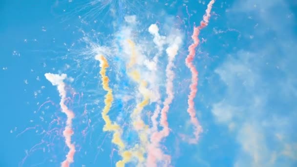 Fuegos artificiales multicolores que explotan en el cielo azul claro brillante durante el día — Vídeo de stock