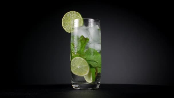 Mojito cocktail med is på en svart bakgrund. — Stockvideo