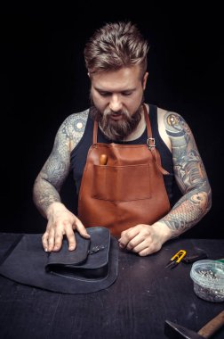 Deri yüzücü deri dükkanında deri kesme işlemini tanıtıyor