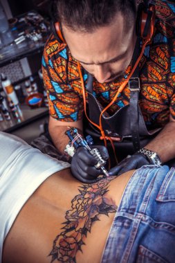 Dövme stüdyosunda dövmeci resmi yapıyor.