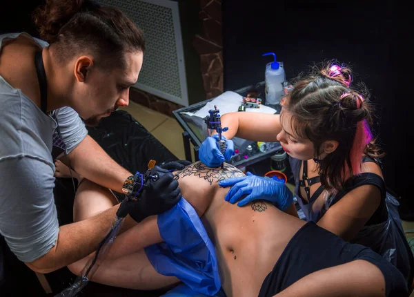 Tattooist does tattoo on the skin of his client in tattoo studio — Stock Photo, Image