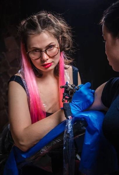 Tattooist making a tattoo in tattoo parlour