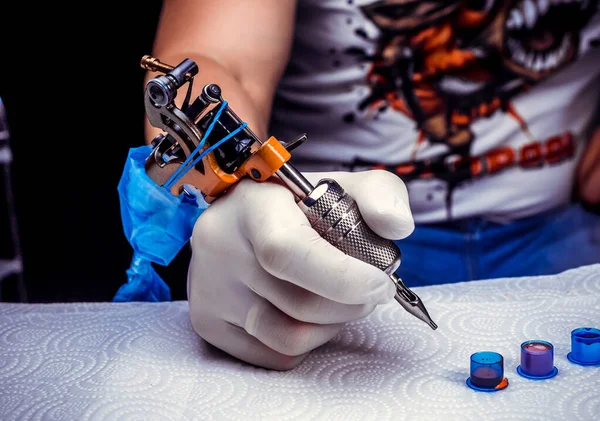 Mano di un tatuatore, che tiene la macchina del tatuaggio. — Foto Stock