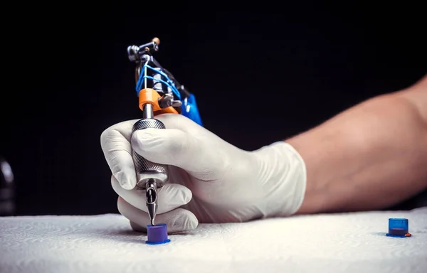 Hand of a tattoo specialist and a tattoo machine. — Stock Photo, Image