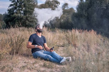 Yakışıklı Vaper duman bulutu salıyor. Vaping konsepti.