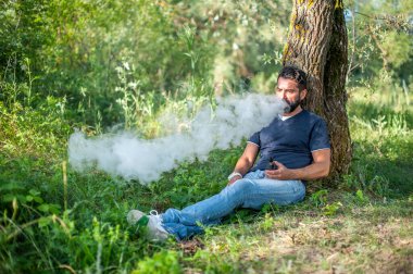 Orman zemininde elektronik duman bombası tüttüren vahşi bir vampir. Sigaraya alternatif.