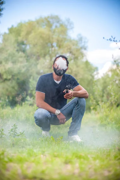 Un bell'uomo vaporizzatore libera una nuvola di vapore. Alternativa al fumo. — Foto Stock