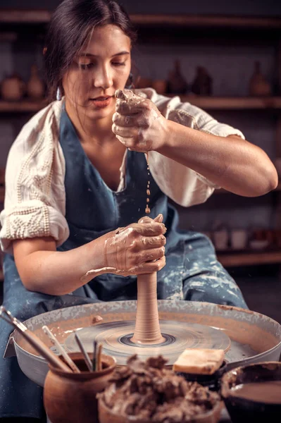 Encantadora joven maestra muestra cómo trabajar con la arcilla y la rueda de cerámica. Concepto para mujer en freelance, negocios, hobby. — Foto de Stock