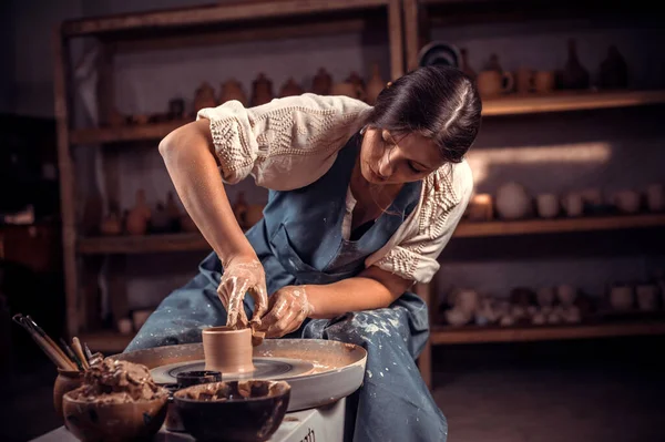 Elegante alfarero profesional que trabaja en la rueda de alfareros con arcilla cruda con las manos. Artesanía nacional. — Foto de Stock