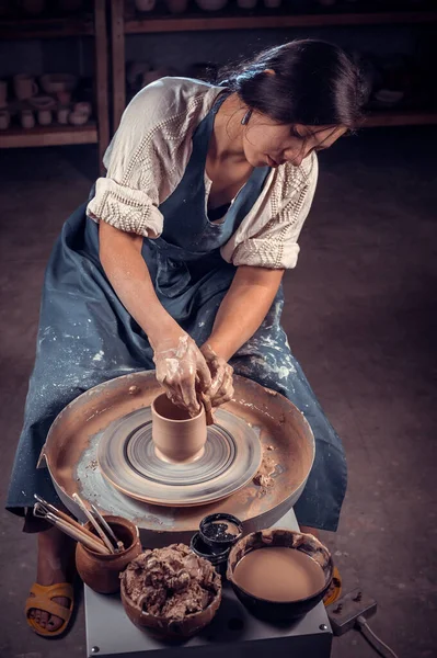 Bella ceramista professionista sta lavorando sulla ruota ceramica. Lavoro manuale. — Foto Stock