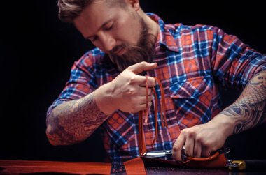 Deri işiyle uğraşan bir zanaatkar deri işi üretir.