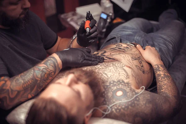 Tattoo specialist works in tattoo studio — Stock Photo, Image