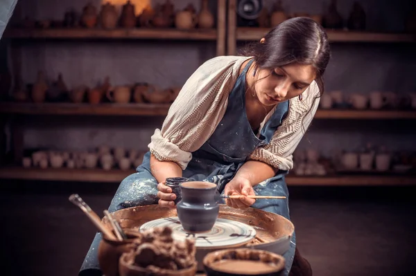 Piękna młoda dama robi ceramiczny garnek na kole garncarskim. Pojęcie kobiety w wolnym strzelcu, biznesu, hobby. — Zdjęcie stockowe