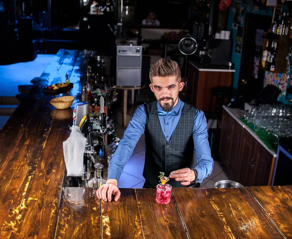 Ο εστιασμένος μπάρμαν διακοσμεί πολύχρωμο παρασκεύασμα στο μπαρ — Φωτογραφία Αρχείου