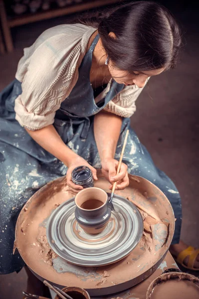 大师在陶工轮上创造了一个陶土罐。陶工的手紧闭着.古代工艺和陶器手工制品 — 图库照片