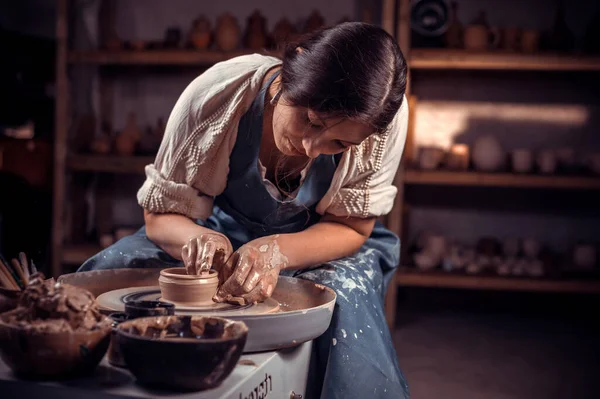 Jonge vrouwelijke pottenbakker werkt aan een pottenbakkerswiel. — Stockfoto