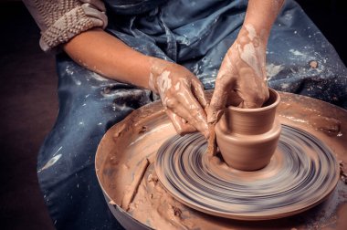 Potter craftsman demonstrates the process of making ceramic dishes using the old technology. Inspiration and creativity. Close-up. clipart