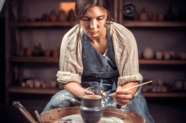 Beau maître céramiste démontre le processus de fabrication de plats en céramique à l'aide de l'ancienne technologie. Artisanat populaire. — Photo