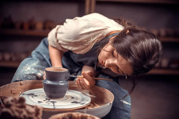 Handen van de pottenbakker en vaas van klei op het pottenbakkerswiel close-up. Meester Crock. Verdraaid pottenbakkerswiel. — Stockfoto