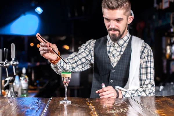 Esperto tapster mette i tocchi finali su un drink mentre in piedi vicino al bancone del bar nel bar — Foto Stock