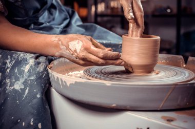 Çömlekçi ustasının elleri ve çömlekçi çarkının üzerindeki vazo yakın plan. Efendi Crock. Çarpık çömlekçiler çarkı.