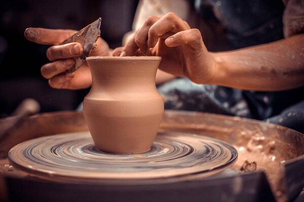 Creating a jar or vase. Master crock. Making clay jug. The sculptor in the workshop makes a jug out of earthenware closeup. Potters wheel. Pottery concept.