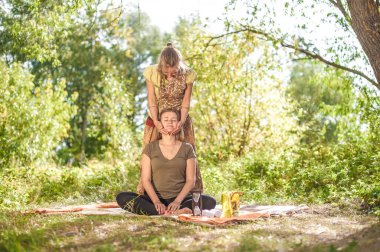 Güzellik tedavisi. Masör ormanda kadın vücuduna masaj yapıyor..