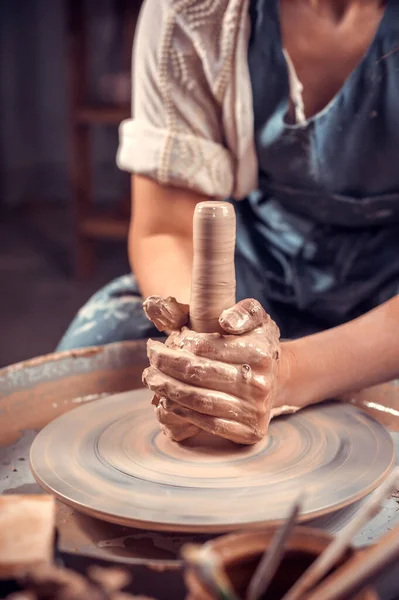 Giovane e allegra donna sta lavorando sulla ruota ceramica. Produzione artigianale. Primo piano. — Foto Stock