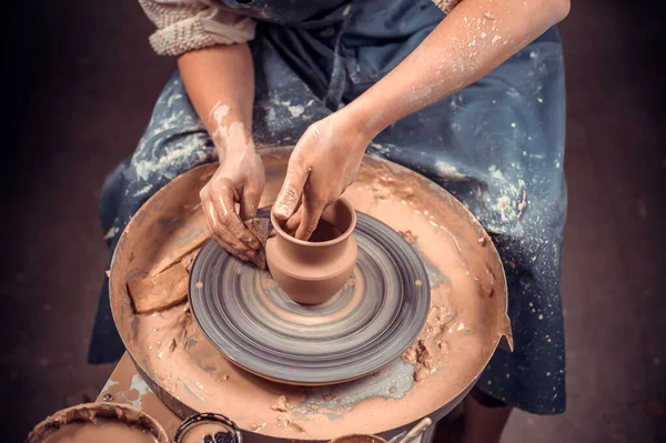 Ten hrnčíř pracuje v dílně. Ruce a hrnčířské kolo detailní záběr — Stock fotografie