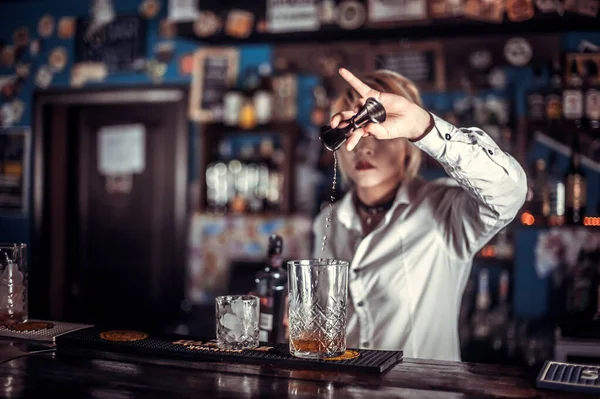Chica experta barman sorpresas con sus visitantes barra de habilidades, mientras que de pie cerca del mostrador de bar en el bar —  Fotos de Stock