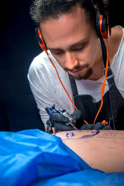 Tatoeëerder die een tattoo maakt in een atelier — Stockfoto