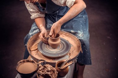 Kil donanımı işleniyor ve bulaşık yapılıyor, işleniyor. El işi seramikleri ve çömlekçi çarkında kil eşyalar.