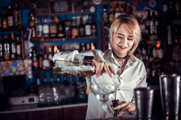 Charmante femme barman formule un cocktail tout en se tenant près du comptoir du bar dans le pub — Photo