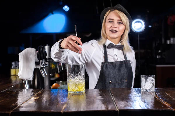 Professionell kvinna mixolog skapar en cocktail när du står nära bardisken i puben — Stockfoto