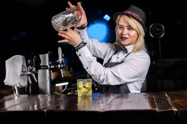 Söt flicka bartender tillför ingredienser till en cocktail bakom bar — Stockfoto
