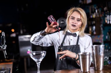 Barmen kız biftekçide kokteyl yapıyor.