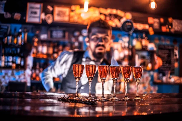 Young barman demonstrates his skills over the counter in the bar — Stock Photo, Image
