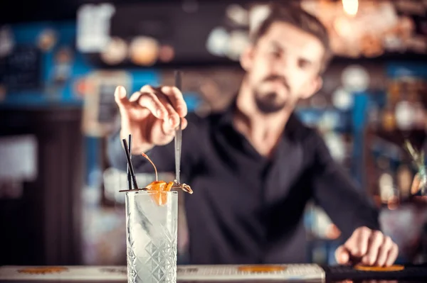 Expert tapster places the finishing touches on a drink on the bar — Stock Photo, Image