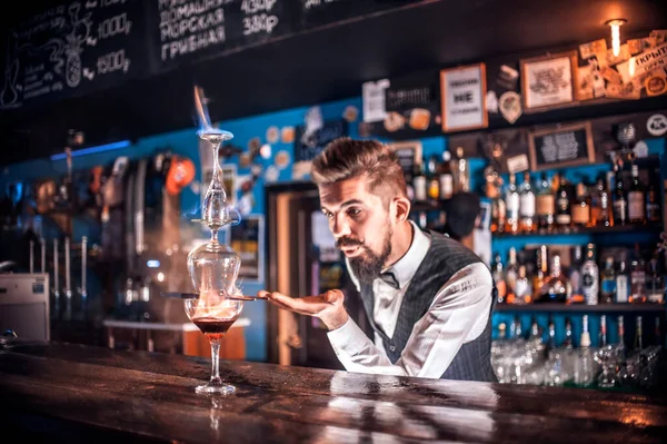 Karismatisk bartender visar sina färdigheter över disken bakom baren — Stockfoto