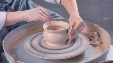 Potter heykeltraşı çömlekçi çarkında kille ve masada aletlerle çalışır. Sanat yaratıcılığı kavramı. Yakın plan..