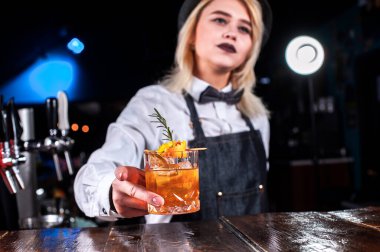 Kız barmen salonda kokteyl hazırlıyor.