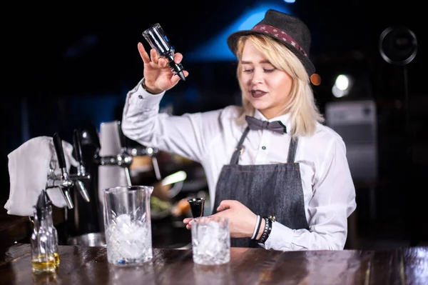 Deneyimli kadın barmen gece kulübünde renkli karışımlar hazırlıyor. — Stok fotoğraf